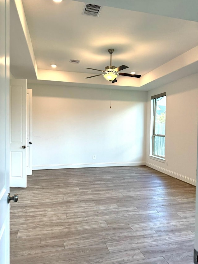 1215 Tallow Park Ln, Pinehurst, TX 77362 - unfurnished room featuring a tray ceiling, a ceiling fan, recessed lighting, wood finished floors, and baseboards