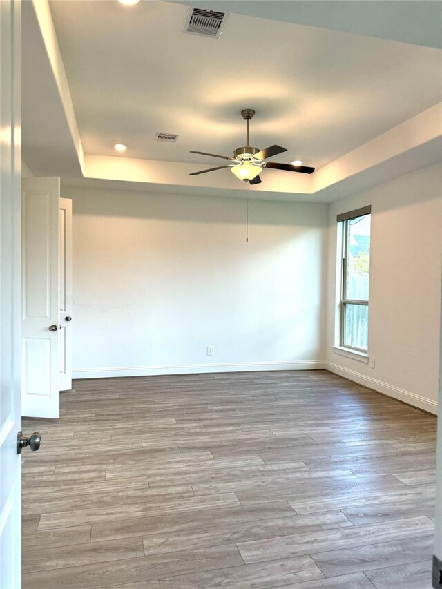 1215 Tallow Park Ln, Pinehurst, TX 77362 - spare room featuring a raised ceiling, a ceiling fan, recessed lighting, and wood finished floors