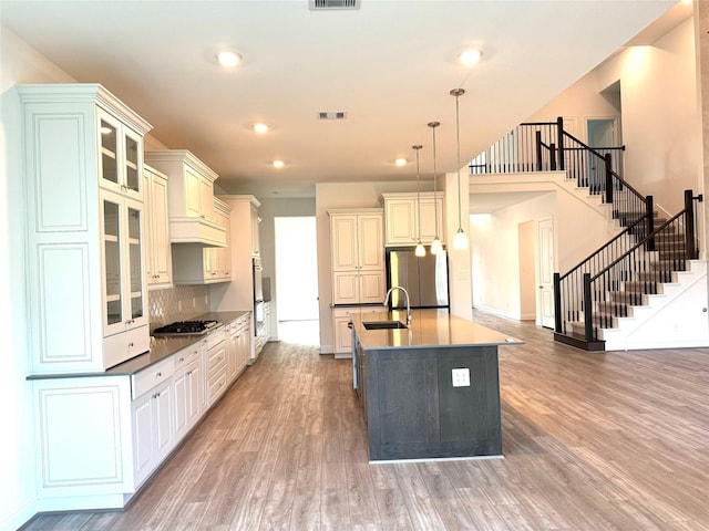 1215 Tallow Park Ln, Pinehurst, TX 77362 - kitchen featuring appliances with stainless steel finishes, light wood-style floors, a sink, recessed lighting, and pendant lighting