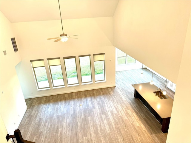 1215 Tallow Park Ln, Pinehurst, TX 77362 - unfurnished living room with high vaulted ceiling, wood finished floors, ceiling fan, and baseboards