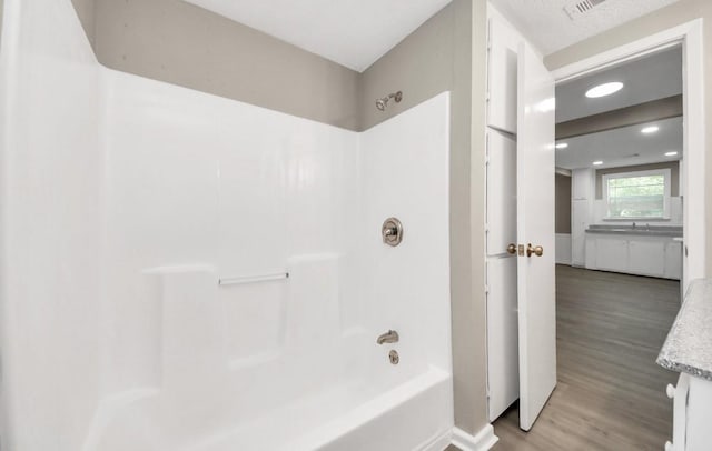 720 Roosevelt St, La Marque, TX 77568 - full bath featuring wood finished floors, bathtub / shower combination, and recessed lighting