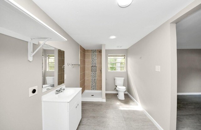 720 Roosevelt St, La Marque, TX 77568 - bathroom with toilet, a stall shower, vanity, baseboards, and wood finished floors