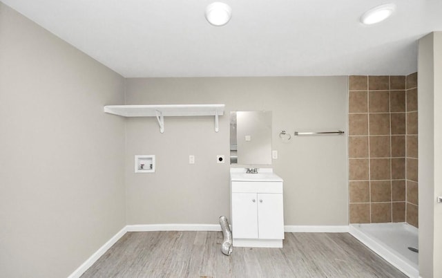 720 Roosevelt St, La Marque, TX 77568 - washroom with electric dryer hookup, washer hookup, light wood-style flooring, cabinet space, and baseboards