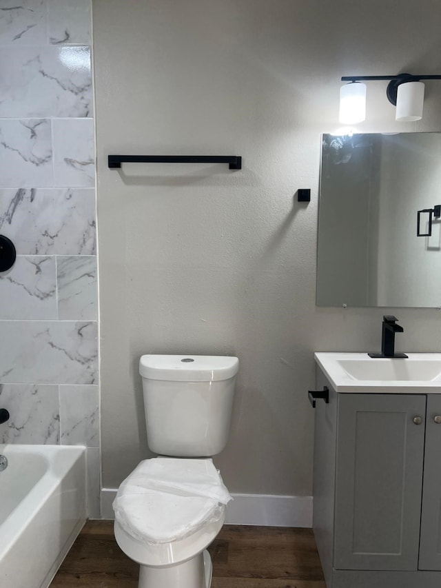 7609 Shotwell St, Houston, TX 77016 - bathroom featuring vanity, wood finished floors, baseboards, and toilet