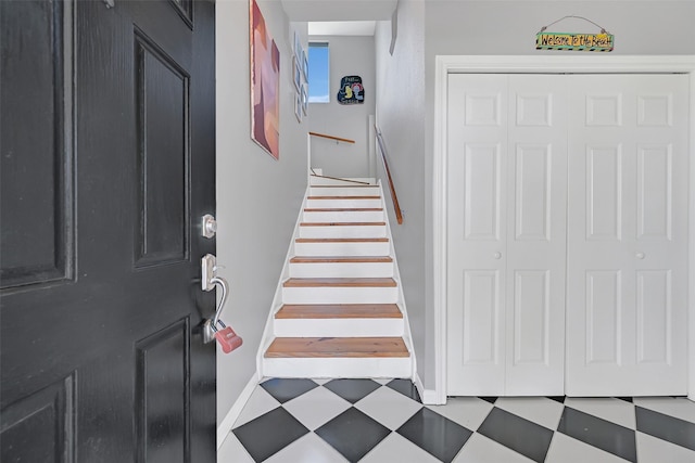 foyer entrance featuring tile patterned floors, baseboards, and stairway
