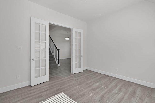 10066 Preserve Way, Conroe, TX 77385 - unfurnished room with french doors, baseboards, wood finished floors, and stairs
