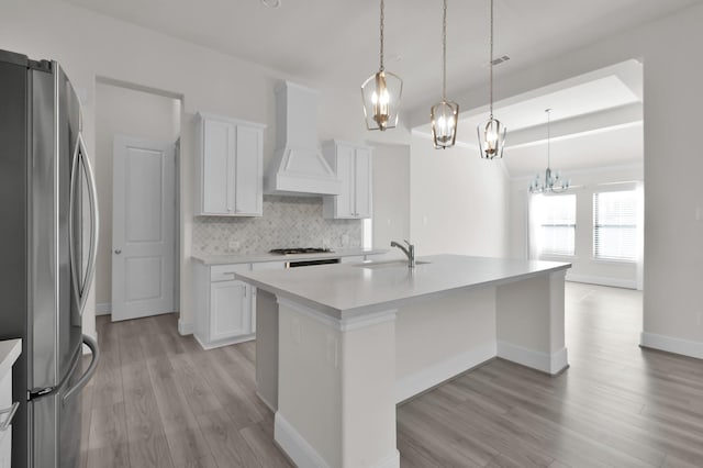 10066 Preserve Way, Conroe, TX 77385 - kitchen featuring freestanding refrigerator, custom range hood, a sink, light wood-style floors, and a chandelier