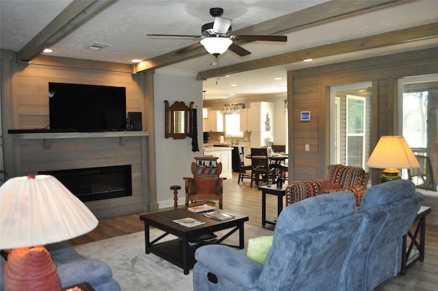 280 Lakewood Cir, Brenham, TX 77833 - living room with beamed ceiling, ceiling fan, light wood-style flooring, a fireplace, and recessed lighting