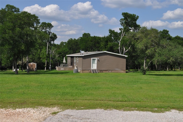 280 Lakewood Cir, Brenham, TX 77833 - view of grassy yard featuring a shed, an outdoor structure, and entry steps