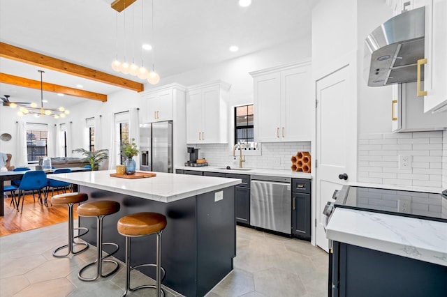 128 N Jenkins St, Houston, TX 77003 - kitchen with appliances with stainless steel finishes, range hood, recessed lighting, a center island, and a breakfast bar