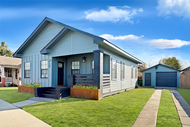 128 N Jenkins St, Houston, TX 77003 - view of front facade with board and batten siding, an outdoor structure, a detached garage, and a front lawn