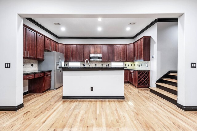 2503 Dallas St, Houston, TX 77003 - kitchen featuring appliances with stainless steel finishes, ornamental molding, tasteful backsplash, light wood finished floors, and a sink