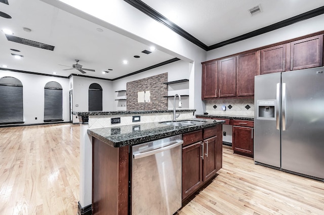 2503 Dallas St, Houston, TX 77003 - kitchen with appliances with stainless steel finishes, a sink, crown molding, light wood-style floors, and tasteful backsplash
