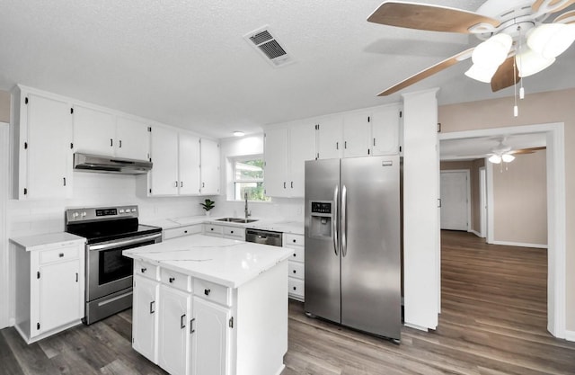 2013 15th Ave N, Texas City, TX 77590 - kitchen featuring stainless steel appliances, under cabinet range hood, dark wood-style flooring, and a textured ceiling