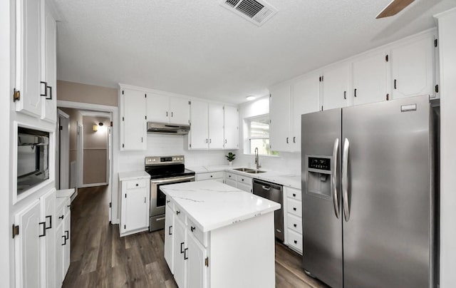 2013 15th Ave N, Texas City, TX 77590 - kitchen featuring appliances with stainless steel finishes, a sink, dark wood-type flooring, a kitchen island, and white cabinets