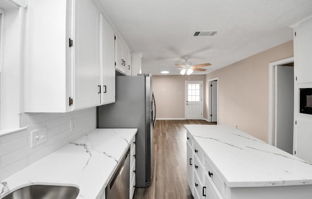 2013 15th Ave N, Texas City, TX 77590 - kitchen featuring a center island, a ceiling fan, light wood-style floors, tasteful backsplash, and white cabinetry