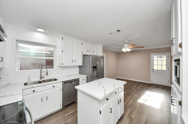 2013 15th Ave N, Texas City, TX 77590 - kitchen with stainless steel appliances, a sink, a ceiling fan, decorative backsplash, and a textured ceiling