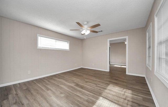 2013 15th Ave N, Texas City, TX 77590 - unfurnished room featuring a ceiling fan, wood finished floors, a textured ceiling, and baseboards