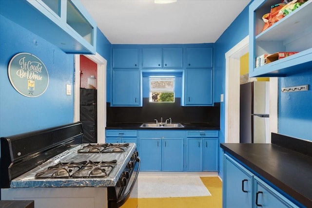 3929 Almeda Genoa Rd, Houston, TX 77047 - kitchen featuring gas stove, a sink, dark countertops, and blue cabinetry