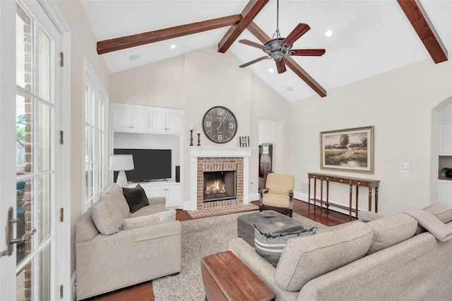living room featuring beamed ceiling, a ceiling fan, high vaulted ceiling, a brick fireplace, and recessed lighting