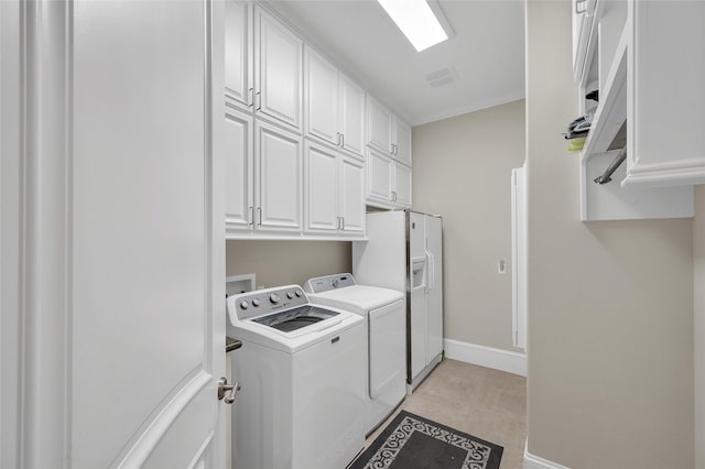 laundry area with washing machine and clothes dryer, cabinet space, and baseboards