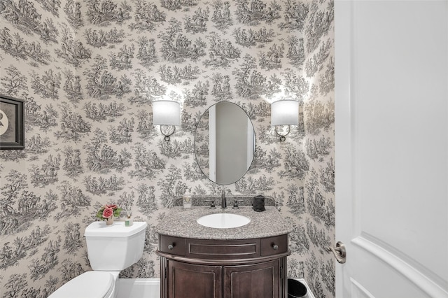bathroom with wallpapered walls, vanity, and toilet