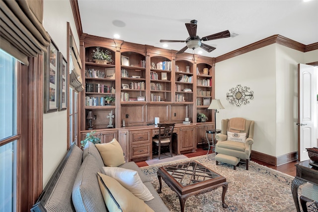 home office with built in desk, a ceiling fan, light wood-type flooring, ornamental molding, and baseboards