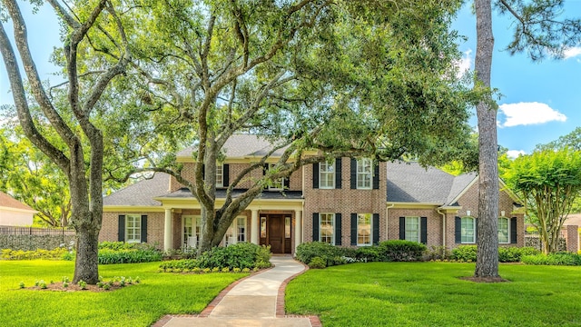 view of front of home featuring a front lawn and brick siding