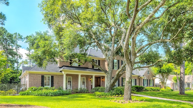 view of front of house featuring brick siding and roof with shingles