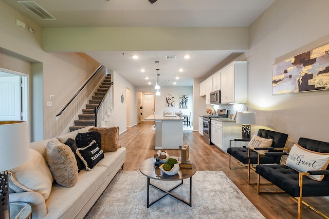 14923 Cutleaf Ln, Cypress, TX 77429 - living area with light wood-style flooring, stairway, recessed lighting, and a ceiling fan