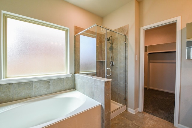 14923 Cutleaf Ln, Cypress, TX 77429 - full bathroom featuring a bath, a stall shower, a walk in closet, and tile patterned flooring