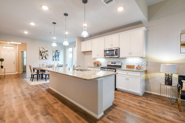 14923 Cutleaf Ln, Cypress, TX 77429 - kitchen featuring appliances with stainless steel finishes, backsplash, white cabinets, light wood-type flooring, and recessed lighting