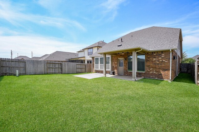 14923 Cutleaf Ln, Cypress, TX 77429 - back of house with a patio area, brick siding, a fenced backyard, and roof with shingles