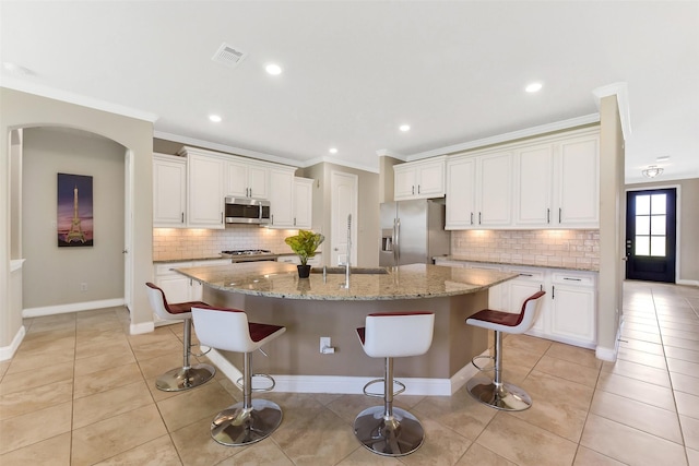 19115 Blooms Rise Dr, Tomball, TX 77377 - kitchen featuring stainless steel appliances, crown molding, decorative backsplash, a large island with sink, and white cabinetry