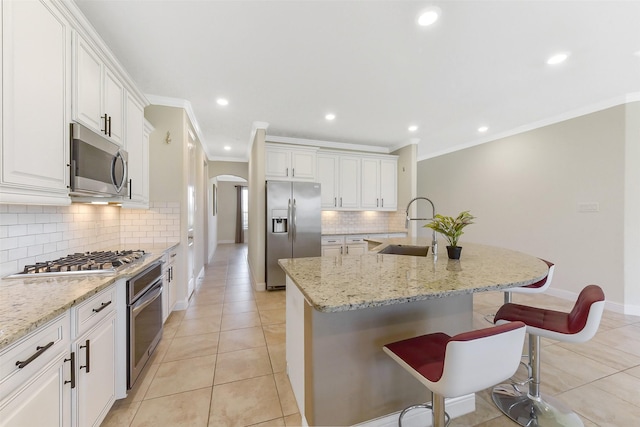 19115 Blooms Rise Dr, Tomball, TX 77377 - kitchen with stainless steel appliances, a sink, arched walkways, tasteful backsplash, and baseboards