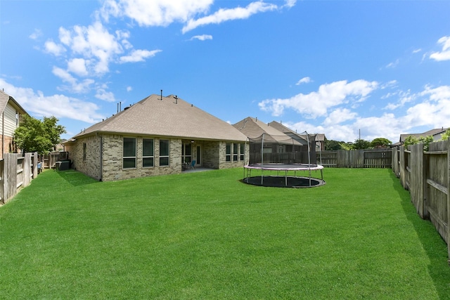 19115 Blooms Rise Dr, Tomball, TX 77377 - back of house featuring a trampoline, brick siding, and roof with shingles