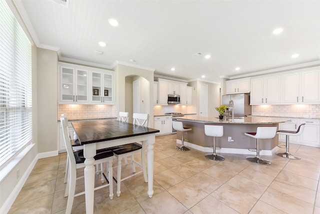 19115 Blooms Rise Dr, Tomball, TX 77377 - kitchen featuring stainless steel appliances, ornamental molding, decorative backsplash, healthy amount of natural light, and a kitchen breakfast bar