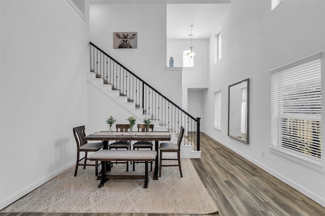 12311 Summerbrook Dr, Houston, TX 77066 - dining space featuring a towering ceiling, stairway, wood finished floors, and baseboards