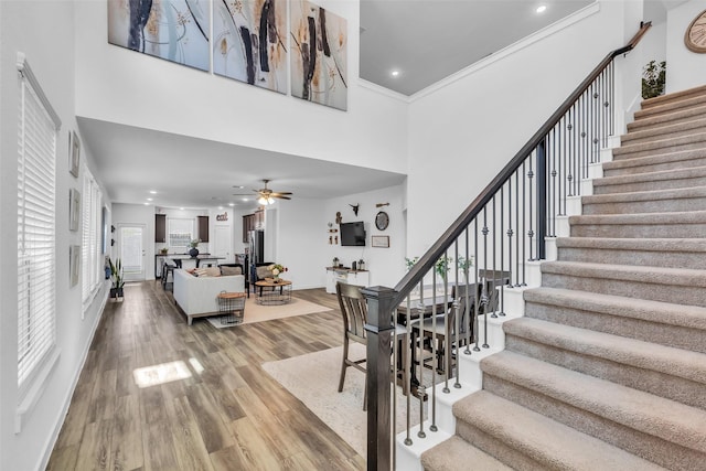12311 Summerbrook Dr, Houston, TX 77066 - staircase featuring a towering ceiling, wood finished floors, ceiling fan, recessed lighting, and ornamental molding