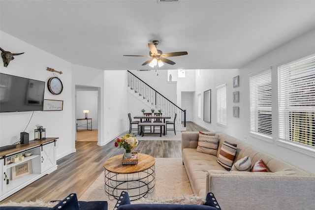 12311 Summerbrook Dr, Houston, TX 77066 - living room with stairs, a ceiling fan, healthy amount of natural light, and wood finished floors