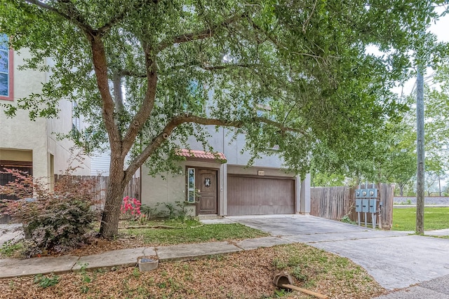 6014 Hamman St, Houston, TX 77007 - view of front facade featuring stucco siding, driveway, fence, and a garage
