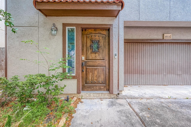 6014 Hamman St, Houston, TX 77007 - doorway to property featuring stucco siding and a garage