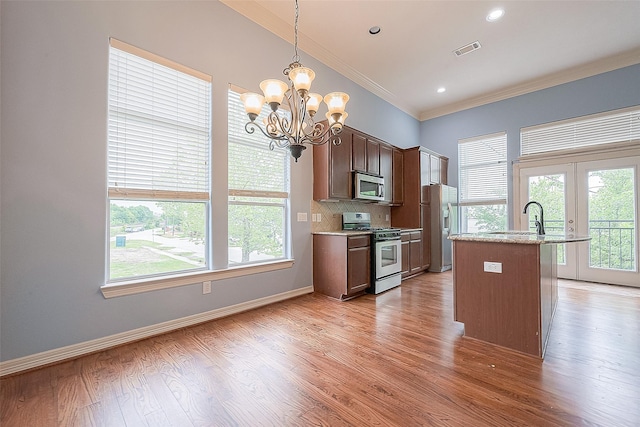 6014 Hamman St, Houston, TX 77007 - kitchen featuring stainless steel appliances, crown molding, healthy amount of natural light, a chandelier, and hanging light fixtures