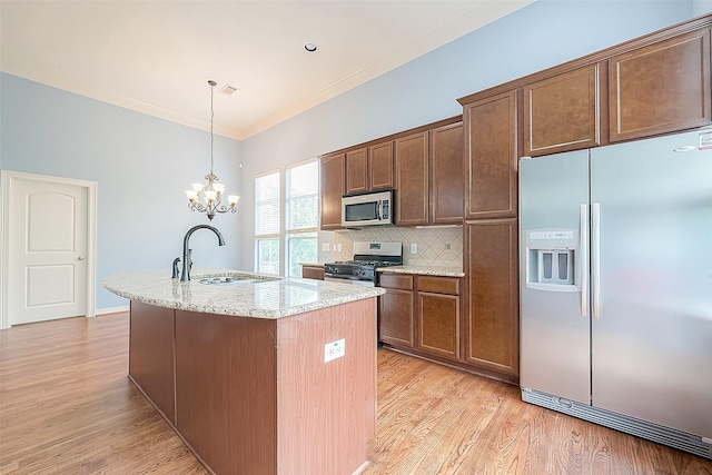 6014 Hamman St, Houston, TX 77007 - kitchen with stainless steel appliances, a sink, crown molding, light wood finished floors, and an island with sink