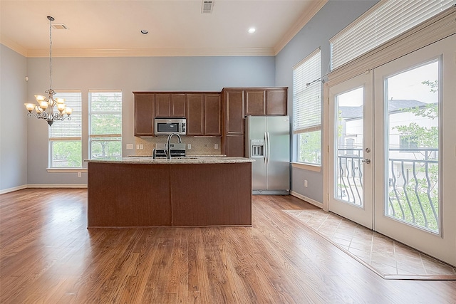 6014 Hamman St, Houston, TX 77007 - kitchen with stainless steel appliances, light wood-type flooring, french doors, a chandelier, and crown molding