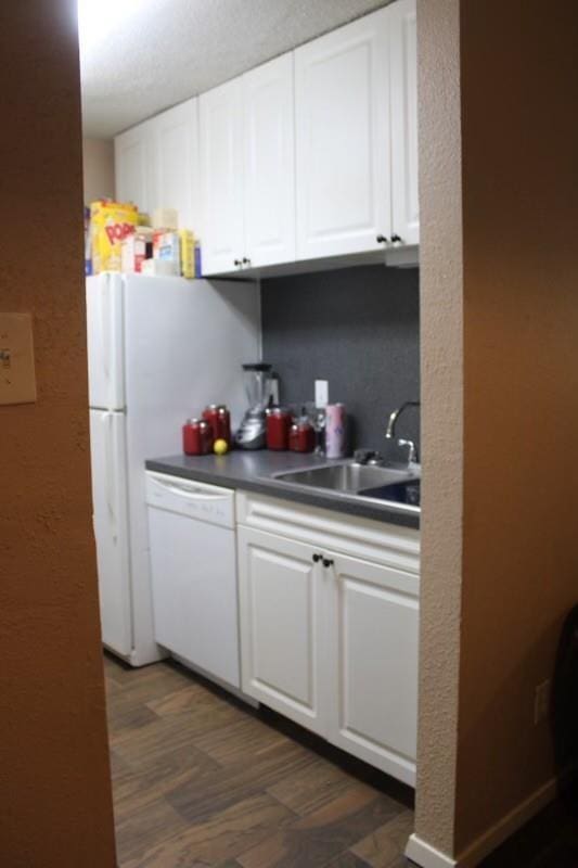 10047 Westpark Dr Unit 46, Houston, TX 77042 - kitchen featuring white dishwasher, white cabinetry, a sink, and dark countertops