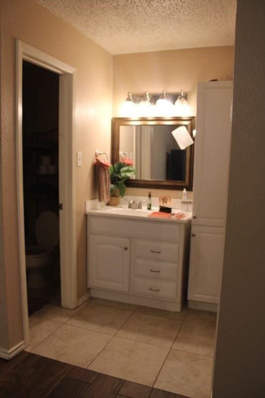 10047 Westpark Dr Unit 46, Houston, TX 77042 - bathroom with a textured ceiling, vanity, tile patterned floors, and toilet
