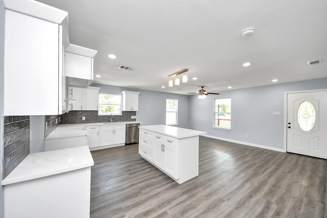 1707 Wilburn, Baytown, TX 77520 - kitchen with stainless steel dishwasher, decorative backsplash, light countertops, a kitchen island, and ceiling fan