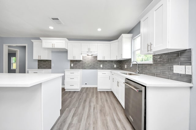 1707 Wilburn, Baytown, TX 77520 - kitchen with dishwasher, a sink, under cabinet range hood, light wood-type flooring, and tasteful backsplash