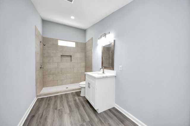 1707 Wilburn, Baytown, TX 77520 - bathroom featuring vanity, toilet, tiled shower, wood finished floors, and recessed lighting
